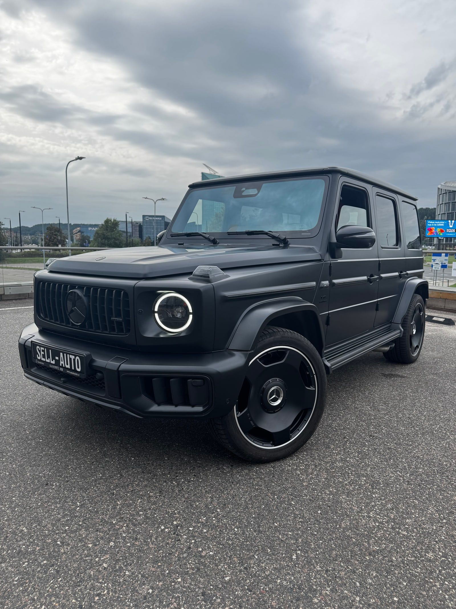 Juodas matinis Mercedes-AMG G klasės visureigis su SELL-AUTO numeriu